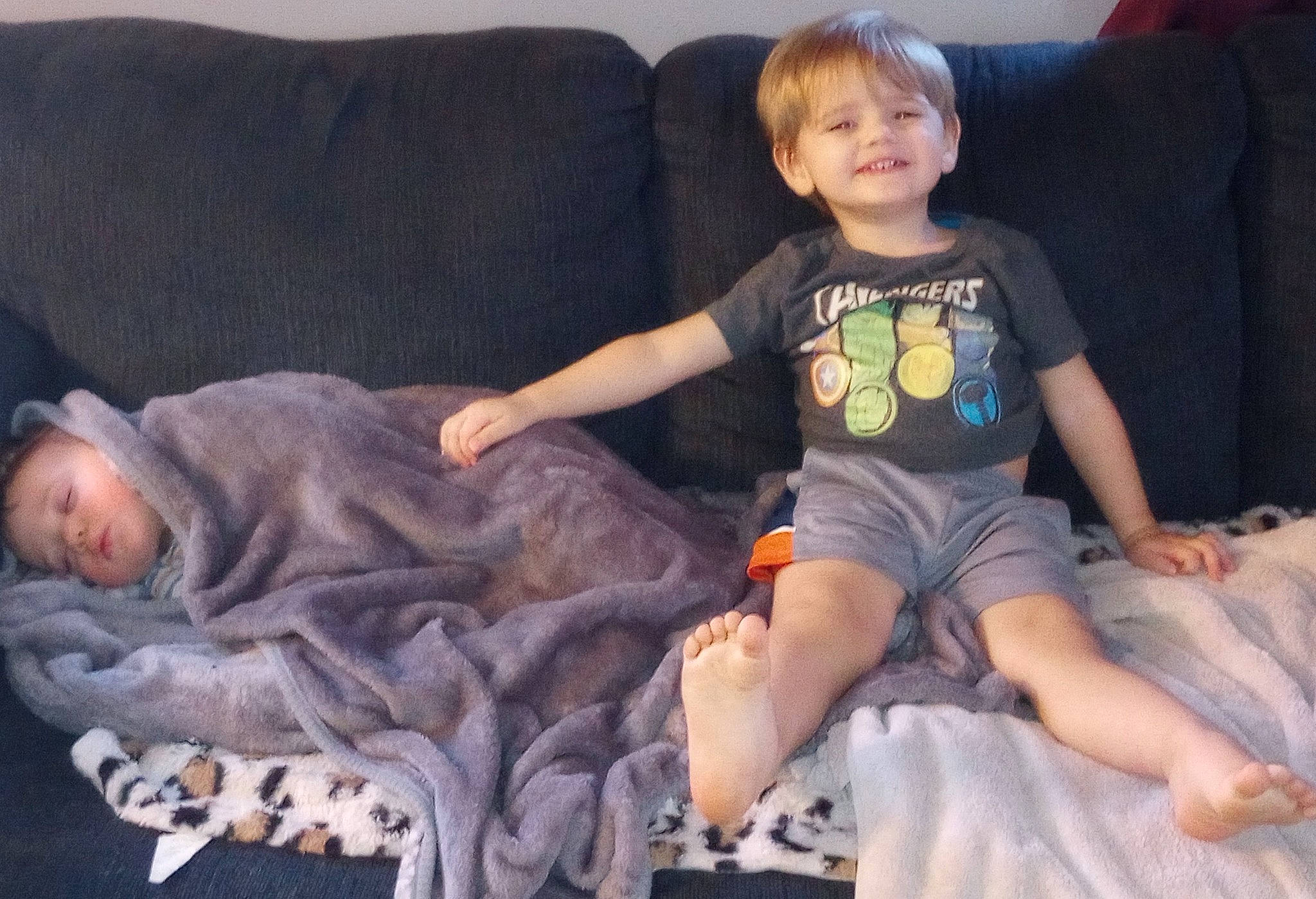 Jj is registered to the contest to win money with this photo: baby_toddler_clothing, child, comfort, couch, face, finger, fun, head, human_leg, iris, joy, lap, person, shorts, sitting, skin, sleeve, smile, sock, textile