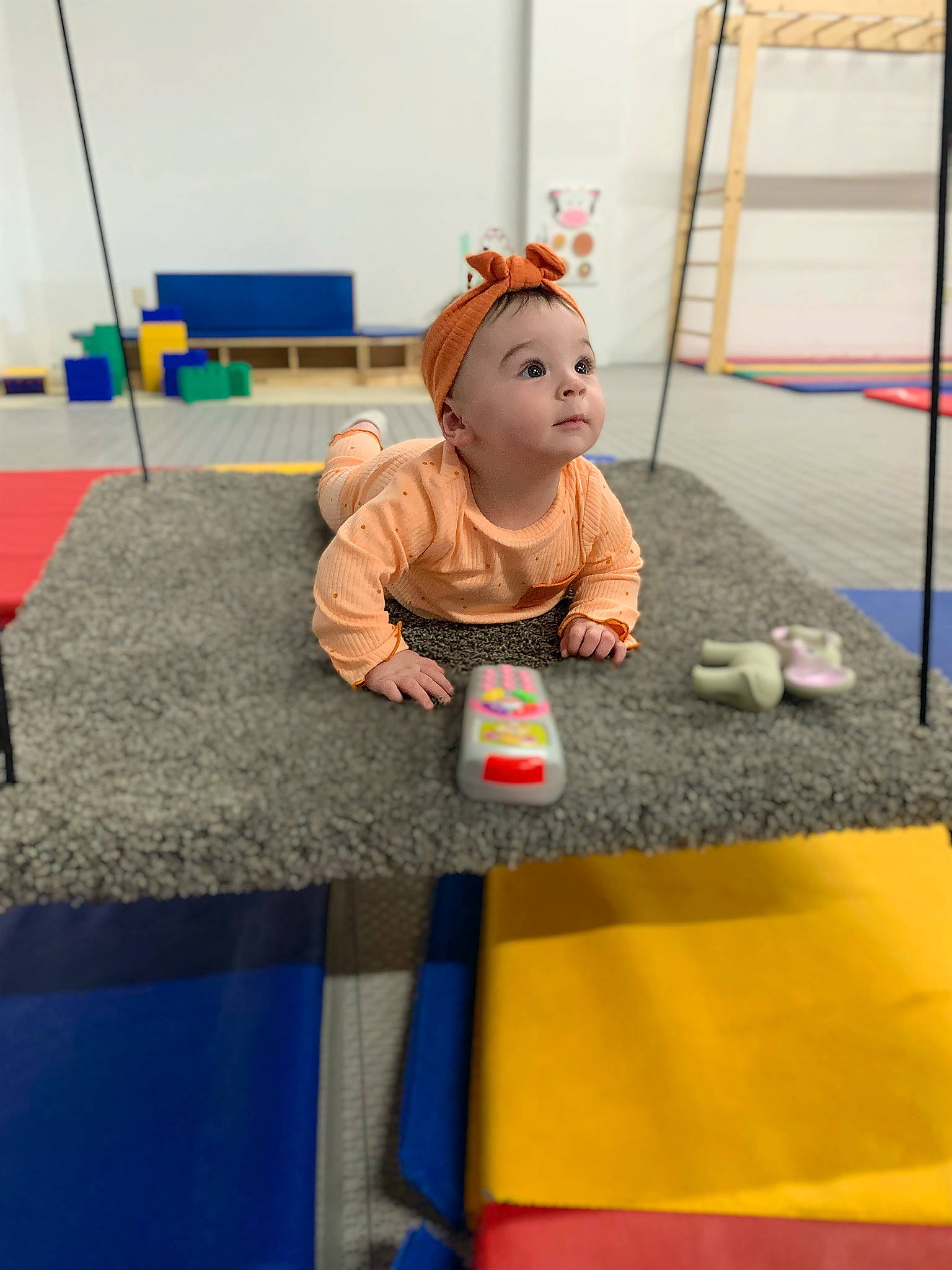Eloise is registered to the contest to win money with this photo: baby, baby_toys, child, doll, event, floor, flooring, fun, leisure, orange, person, play, recreation, room, sitting, stuffed_toy, table, textile, toddler, toy