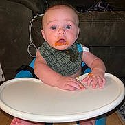 Ryley joined the competition — help win amazing prizes! baby, barefoot, bib, blue_eyes, child, expression, face, feeding_time, feet, food_mess, hands, high_chair, indoor, infant, living_room, messy, person, sofa, surprised, wooden_floor