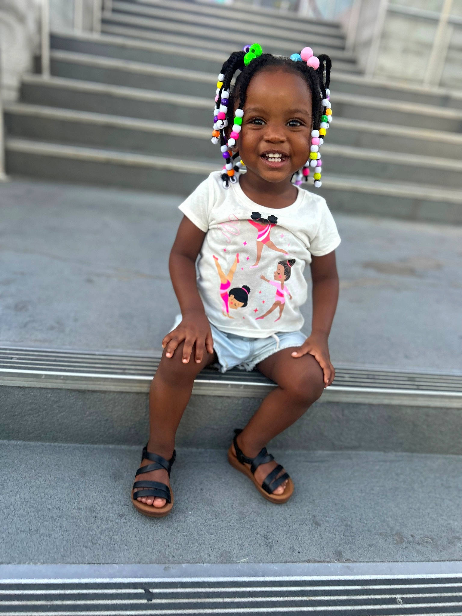 Imani is registered to the contest to win money with this photo: asphalt, baby_toddler_clothing, child, eyewear, flip_flops, fun, happy, human_leg, magenta, person, recreation, road, sandal, shorts, sidewalk, smile, snapshot, street, t_shirt, thigh