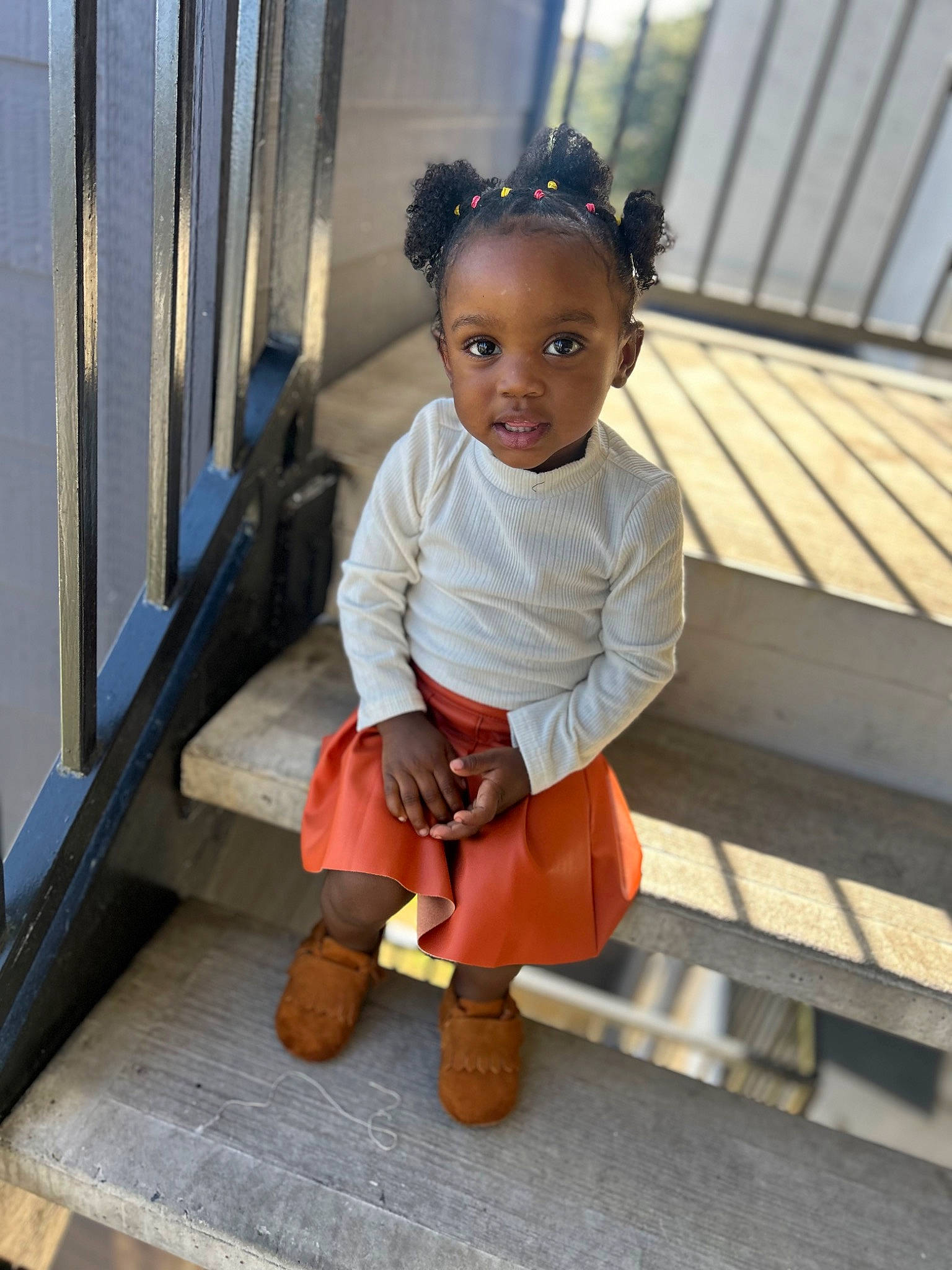 Imani joined the competition — help win amazing prizes! baby_toddler_clothing, child, door, eye, flooring, fun, hairstyle, happy, hardwood, human_leg, jewellery, person, sitting, skin, sleeve, smile, standing, thigh, toddler, wood