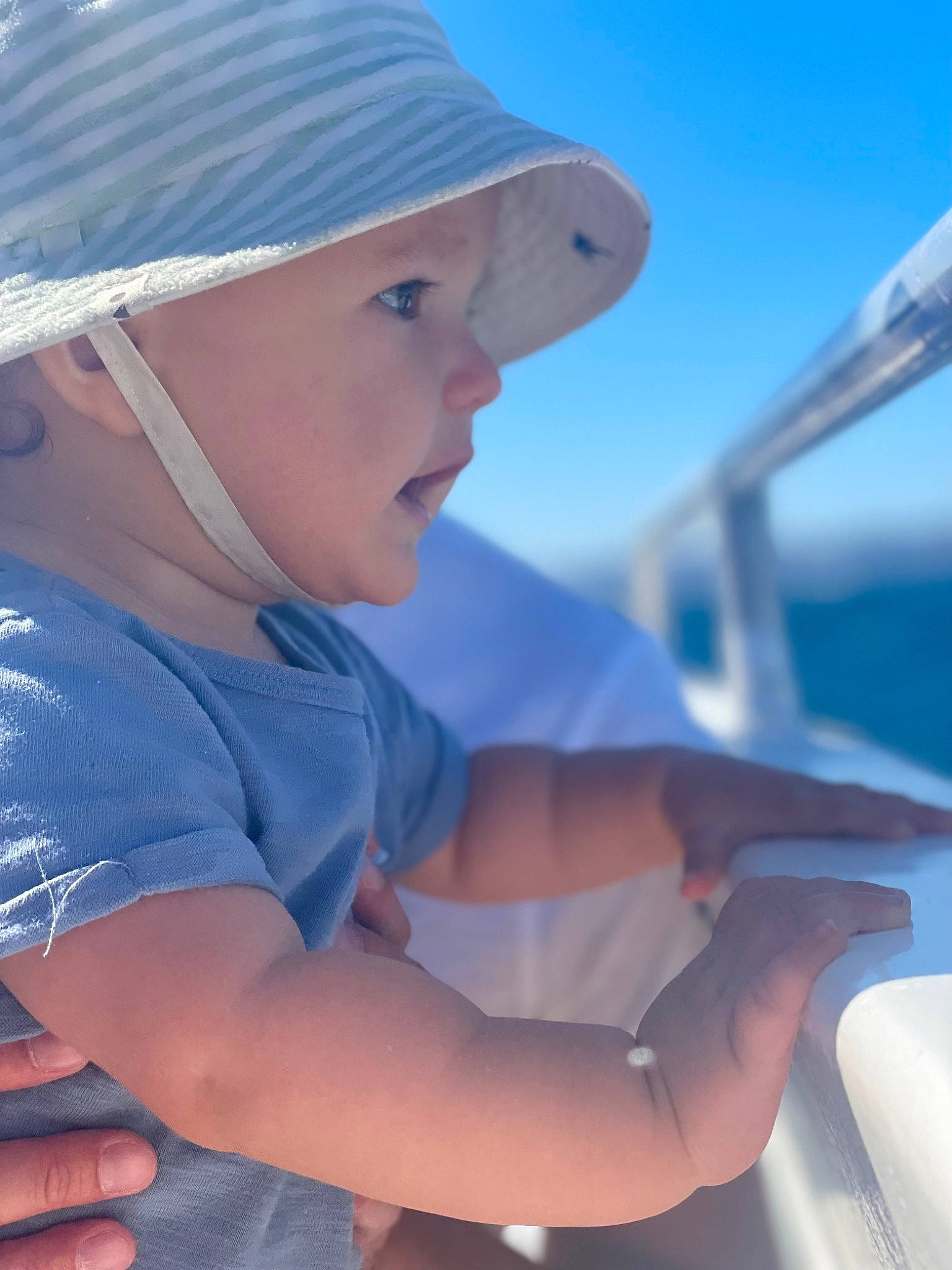 Ezra a rejoint le concours — aidez-le/la à gagner de superbes lots ! azure, baseball_cap, boat, boats_and_boating_equipment_and_supplies, cap, elbow, electric_blue, fun, happy, hat, headwear, leisure, naval_architecture, person, recreation, shoulder, sky, sun_hat, sunlight, toddler