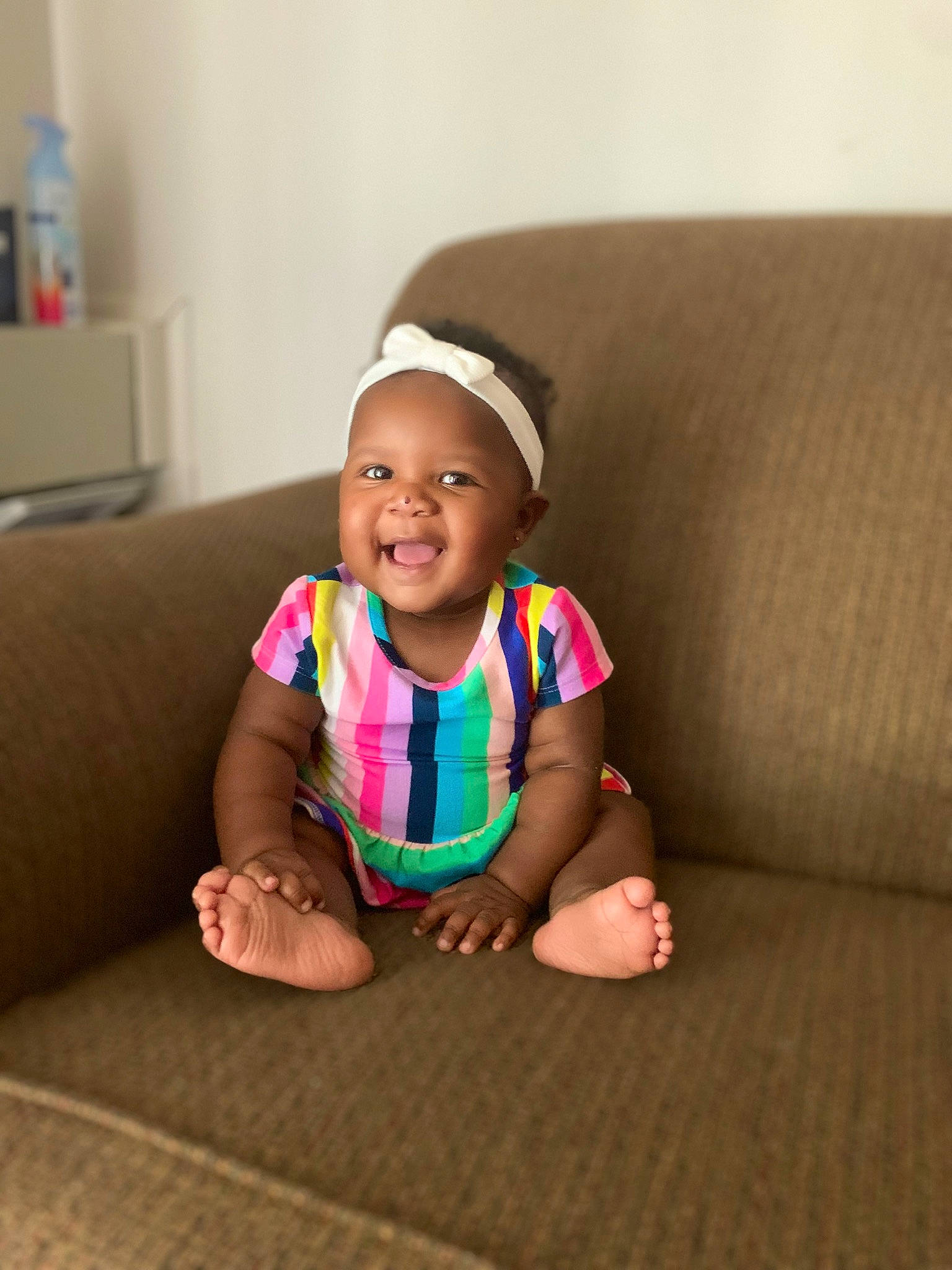 Lillyana is registered to the contest to win money with this photo: baby, baby_toddler_clothing, cheek, comfort, couch, dress, face, floor, flooring, fun, happy, head, human_leg, joy, mammal, person, skin, sleeve, smile, t_shirt