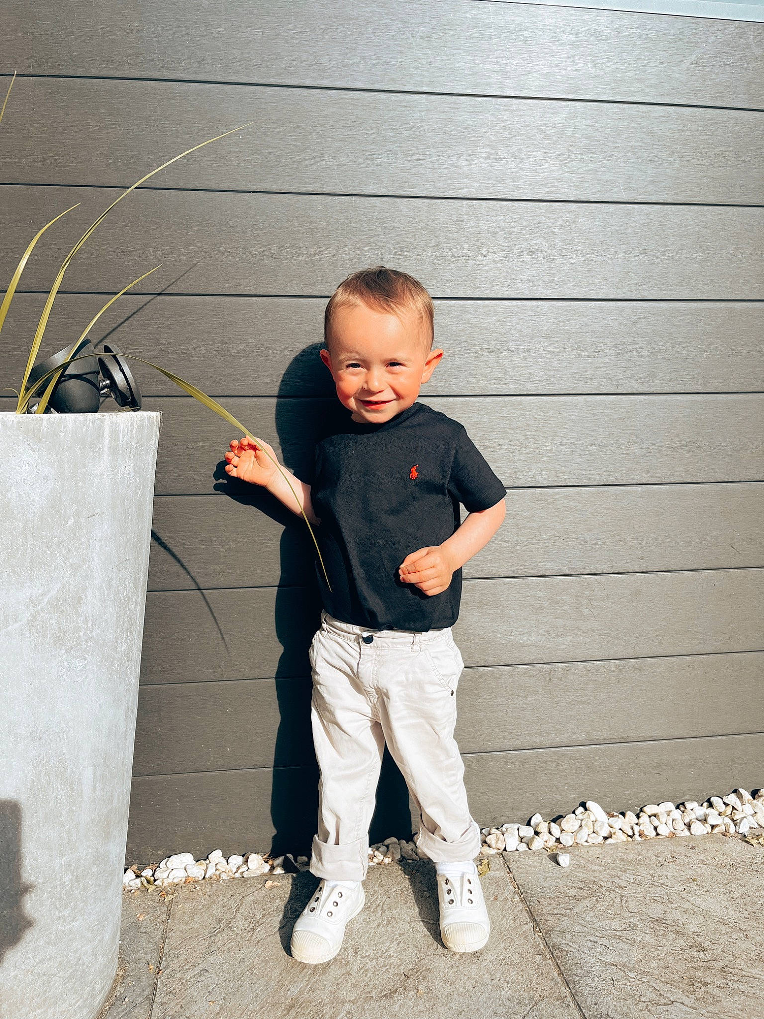 Simao a rejoint le concours — aidez-le/la à gagner de superbes lots ! brick, child, concrete, flash_photography, flooring, fun, gesture, happy, joy, person, portrait_photography, shadow, sitting, sleeve, standing, t_shirt, toddler, wall, wood