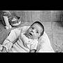 baby, basket, black_and_white, blanket, candles, child, cozy, curious, cushion, cute, expression, face, gaze, indoors, infant, knitwear, portrait, seat, soft_lighting, wooden_floor
