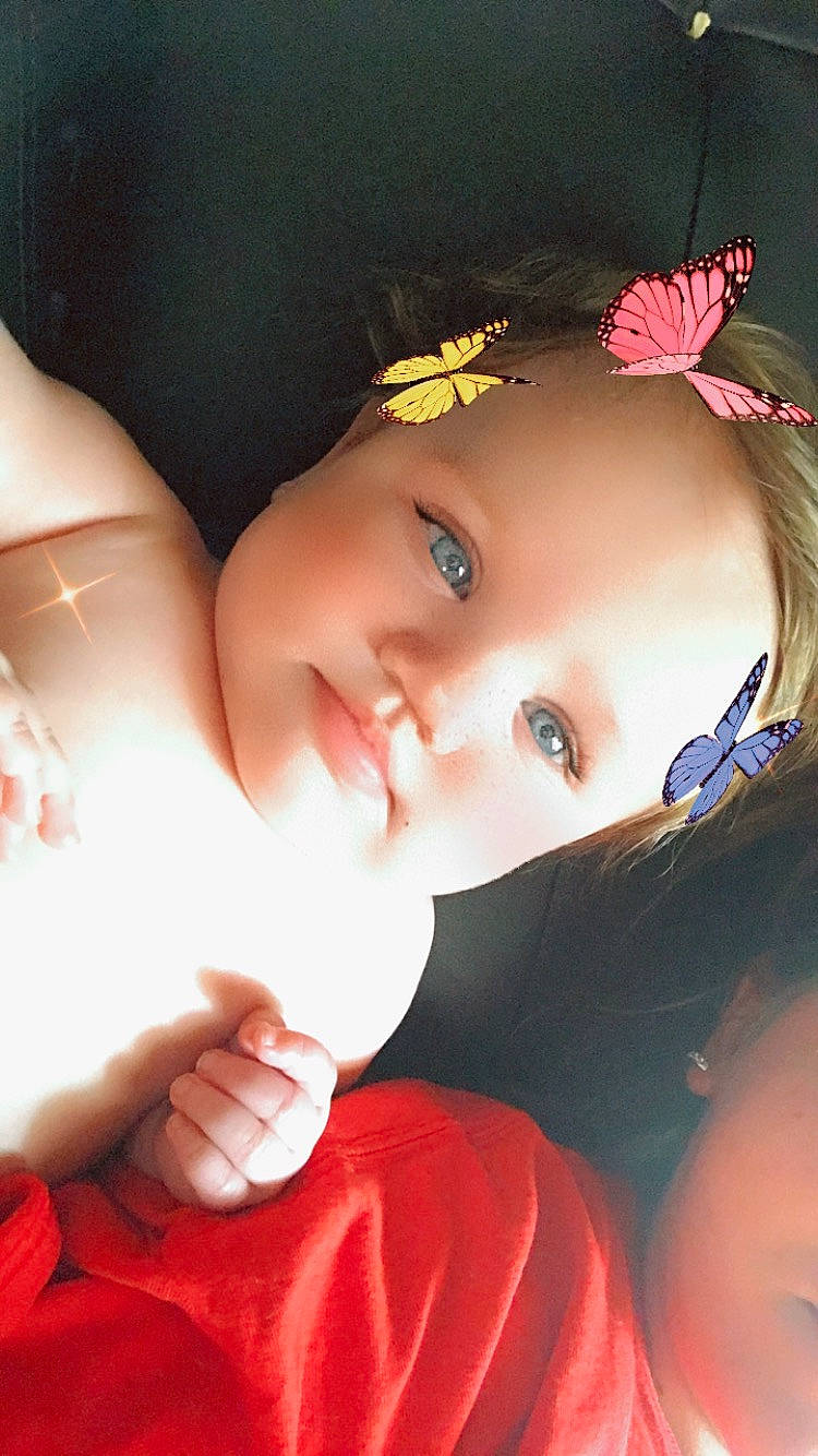 Mayla joined the competition — help win amazing prizes! baby, black_hair, cheek, child, chin, close_up, eye, eyebrow, eyelash, flash_photography, gesture, happy, headpiece, iris, lip, person, petal, pink, skin, toddler