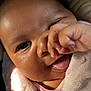 Grace is registered to the contest to win money with this photo: baby, close_up, face, tongue, hand, pink_blanket, infant, skin, cute, expression, child, soft_light, portrait, newborn, smile, warmth, cozy, fingers, person, young