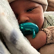 Seven is registered to the contest to win money with this photo: baby, pacifier, blanket, hat, sleepy, closeup, infant, cozy, child, soft, cuddle, peaceful, resting, cute, face, hand, clothing, indoors, skin, portrait