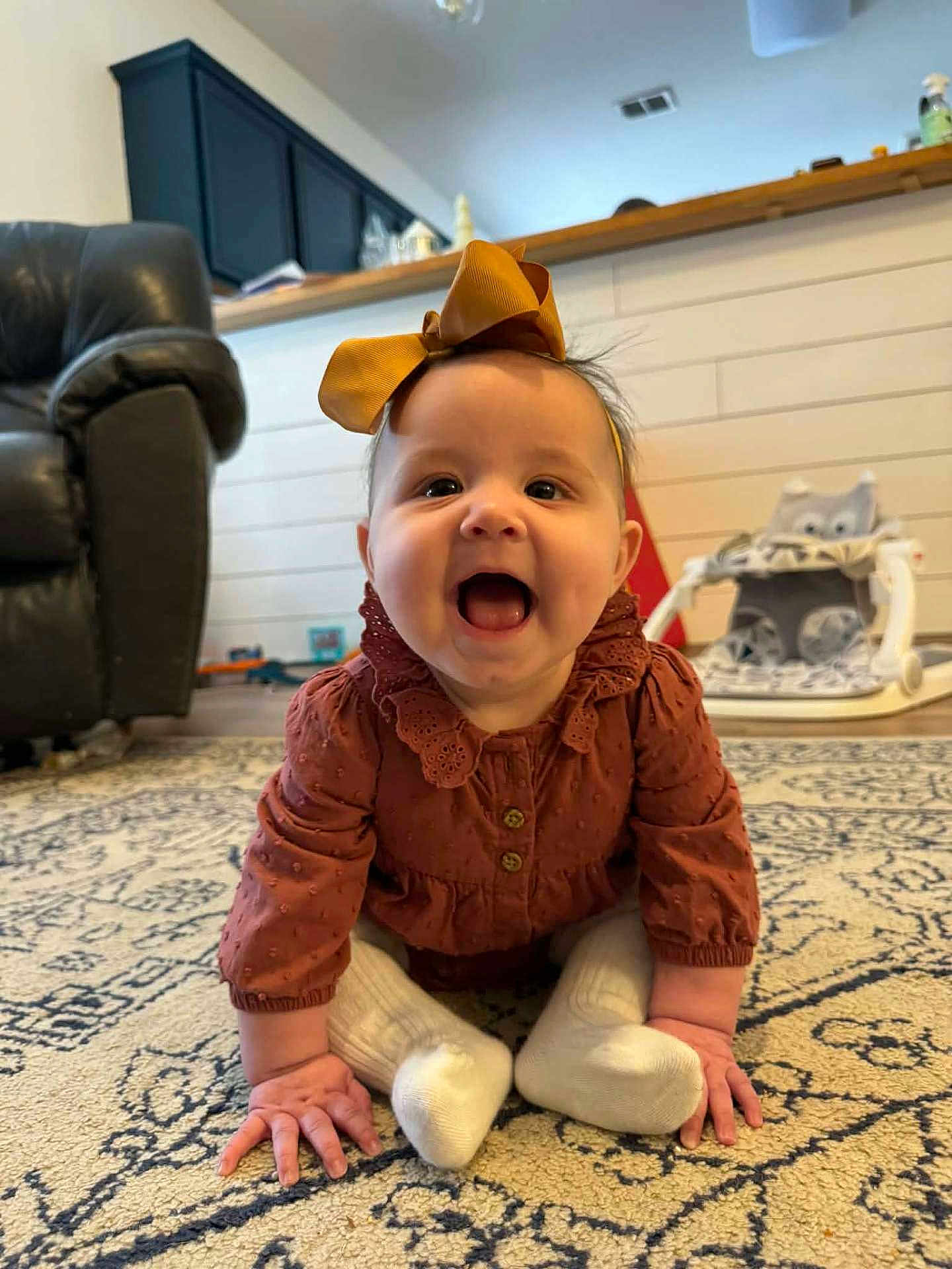 Mia joined the competition — help win amazing prizes! baby, child, smiling, sitting, carpet, indoor, clothing, bow, sock, happy, face, person, home, furniture, toy, floor, cute, infant, portrait, cozy