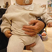 Nino a rejoint le concours — aidez-le/la à gagner de superbes lots ! baby, pacifier, hat, beige_clothing, adult_hand, indoor, toy, shelf, floor, curious, child, footwear, warm_clothing, infant, person, holding, soft_lighting, cute, toddler, furniture