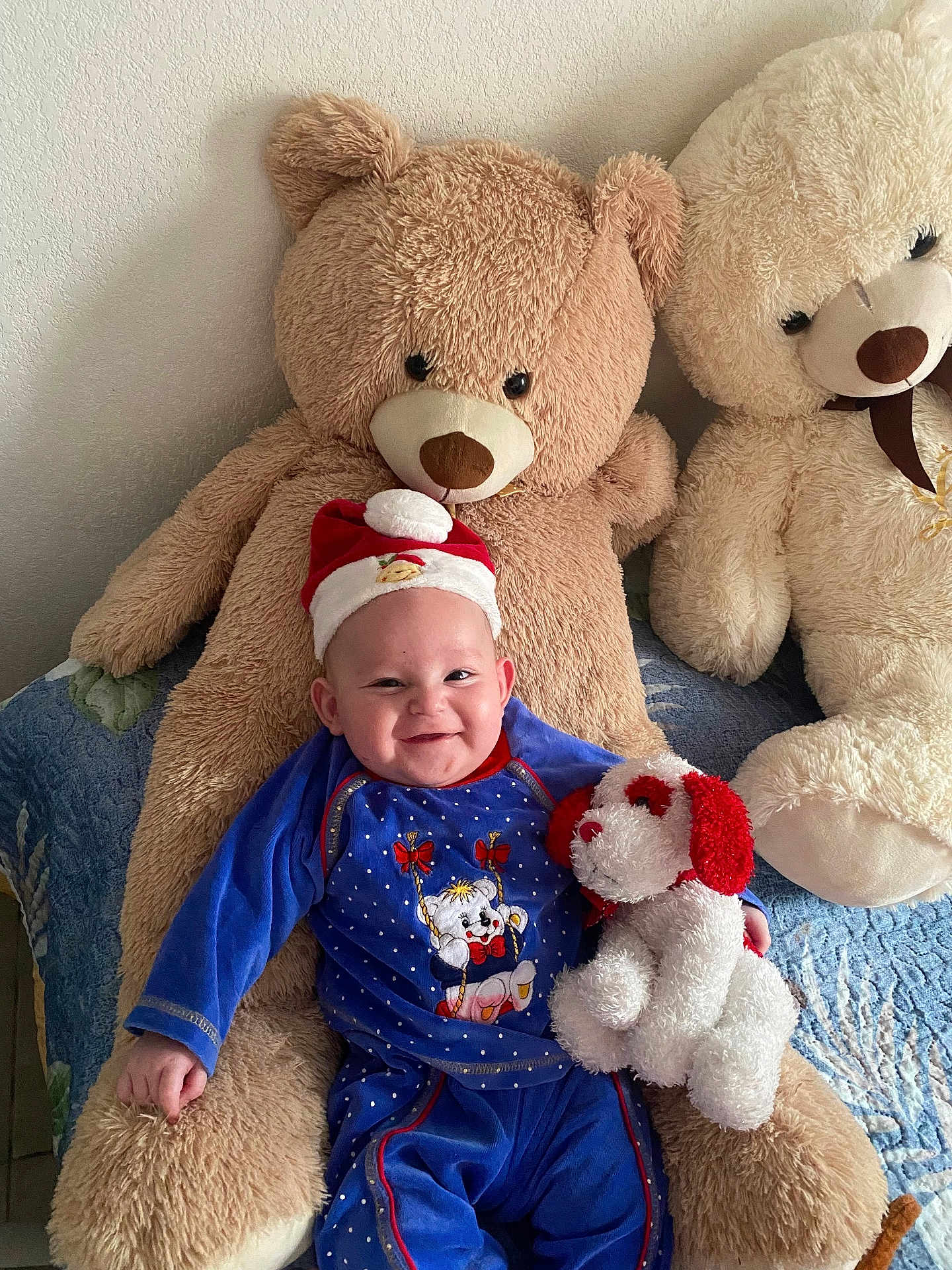 Souleymane participe au concours pour gagner de l'argent avec cette photo : baby, child, teddy_bear, stuffed_animal, plush_toy, blue_clothing, smiling, hat, indoor, bedspread, cute, happy, person, holiday_hat, soft_toy, seated, cuddly, toy_dog, fabric, home