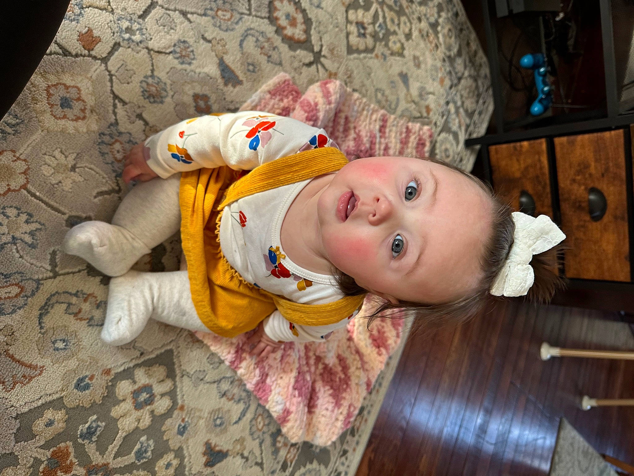 Elena is registered to the contest to win money with this photo: baby, baby_products, baby_safety, baby_toddler_clothing, child, comfort, eye, flooring, fur, hardwood, hat, head, linens, nightwear, person, room, sitting, surprise, toddler, toy