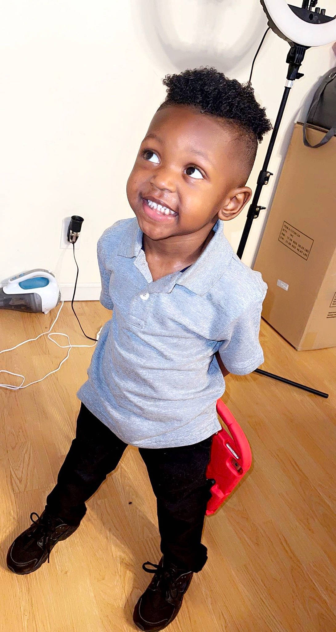 Juelz is registered to the contest to win money with this photo: baby_toddler_clothing, boot, child, electric_blue, fashion_design, flooring, happy, hardwood, joint, joy, knee, neck, person, shoulder, sleeve, smile, standing, t_shirt, thigh, toddler