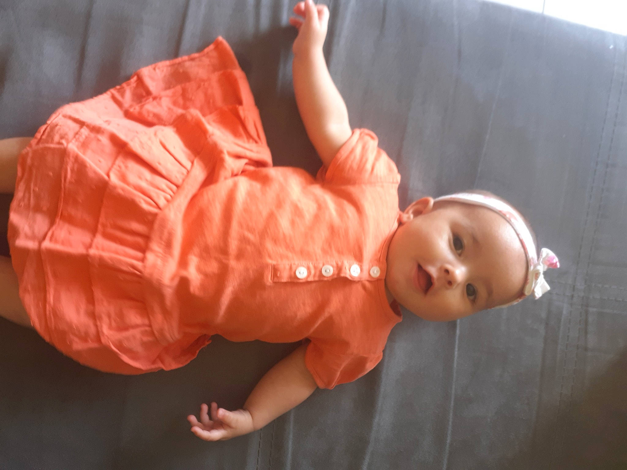 Inès participe au concours pour gagner de l'argent avec cette photo : baby, baby_toddler_clothing, cheek, child, comfort, doll, elbow, flooring, fun, gesture, happy, peach, person, sitting, skin, sleeve, thumb, toddler, toy, wood