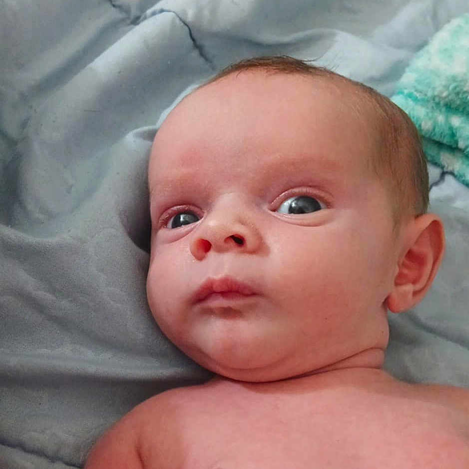 Emerson joined the competition — help win amazing prizes! baby, bed, blanket, child, comfort, curious, expression, eyes, face, head, indoors, infant, lying_down, newborn, person, shoulder, skin, soft, torso, young