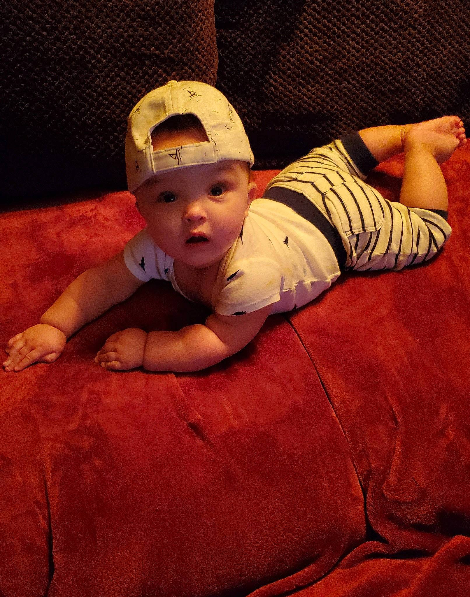 Archer is registered to the contest to win money with this photo: baby, baby_toddler_clothing, baseball_cap, cap, child, comfort, elbow, eye, finger, flash_photography, happy, hat, head, headgear, headwear, linens, mouth, person, skin, sleeve