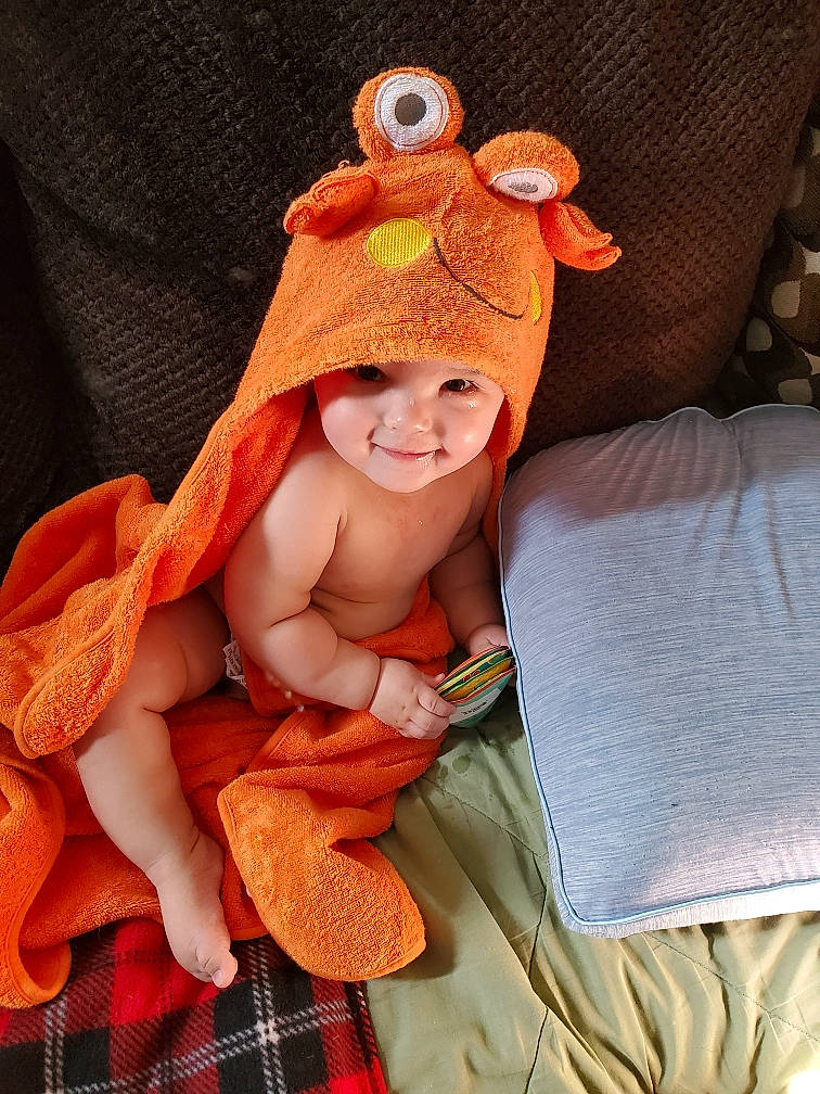 Archer is registered to the contest to win money with this photo: baby, baby_sleeping, baby_toddler_clothing, cap, child, comfort, costume_hat, fawn, happy, headwear, human_body, linens, orange, pattern, peach, person, plaid, smile, stuffed_toy, tartan