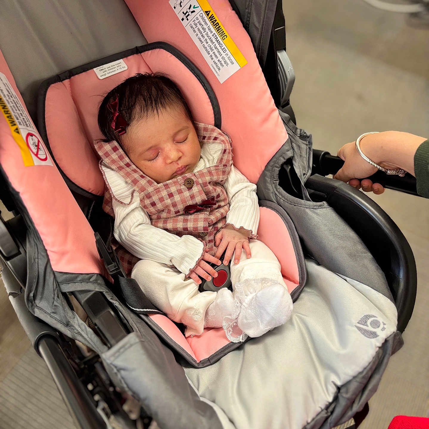 Lydia joined the competition — help win amazing prizes! baby, sleeping, stroller, infant, portrait, indoors, pink, carriage, clothing, checked_pattern, blanket, cushion, hand, adult, parent, peaceful, nap, seated, safety_label, wheelchair_like_stroller