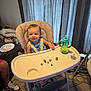 baby, high_chair, smiling, food, sippy_cup, pacifier, indoor, curtains, carpet, person, child, furniture, dog, plate, shoe, floor, table, feeding, happy, blue_clothing