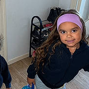Lahïna a rejoint le concours — aidez-le/la à gagner de superbes lots ! child, indoor, smiling, backpack, headband, long_hair, boots, shoe_rack, wooden_floor, casual_clothing, pants, shoes, person, young_child, standing, happy, playful, purple_headband, blue_backpack, cartoon_character