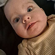 Ivy is registered to the contest to win money with this photo: baby, close_up, face, eyes, infant, child, portrait, expression, cute, curious, skin, person, clothing, striped, laying_down, long_eyelashes, soft_lighting, indoors, head, young