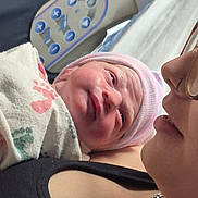 Kayelynn is registered to the contest to win money with this photo: newborn, baby, infant, child, face, portrait, sleepy, hospital, blanket, hat, pink, cuddling, adult, parent, closeup, indoor, medical_equipment, birth, family, photography