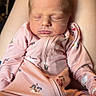 newborn, baby, sleeping, infant, portrait, pink, onesie, clothing, animal_print, dog_pattern, sitting, lap, indoors, cozy, peaceful, closed_eyes, face, head, child, photography
