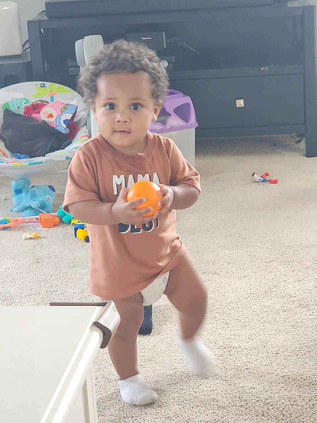 Zacc joined the competition — help win amazing prizes! toddler, child, indoor, carpet, toy, orange_ball, brown_shirt, diaper, white_sock, furniture, living_room, curly_hair, person, playtime, cute, standing, carpeted_floor, plastic_toy, baby_chair, candid