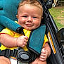 Elijah joined the competition — help win amazing prizes! baby, smiling, stroller, yellow_shirt, diaper, child, outdoor, seatbelt, blue_eyes, cute, infant, happy, portrait, hair, hand, shoulder_strap, fabric, greenery, daylight, skin