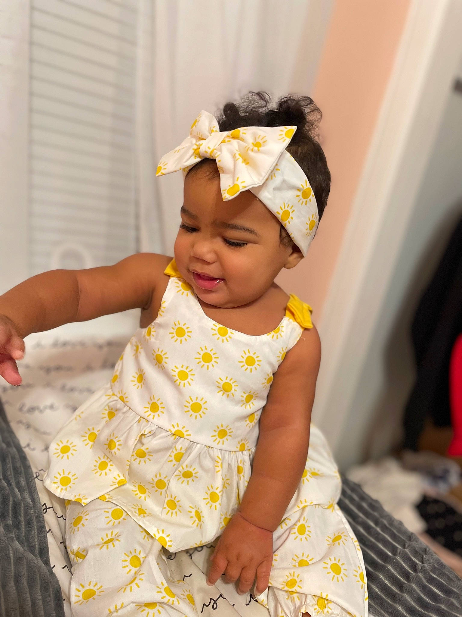 Aaliyah is registered to the contest to win money with this photo: baby, baby_products, baby_toddler_clothing, child, comfort, day_dress, event, fun, hair_accessory, happy, headband, headpiece, headwear, linens, pattern, person, room, sitting, skin, sleeve
