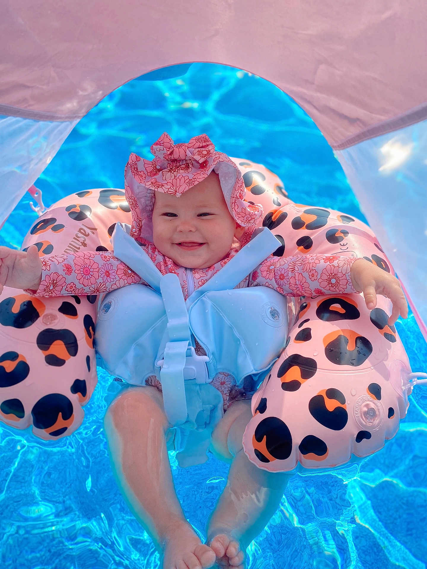 Kovelynn is registered to the contest to win money with this photo: baby, swimming_pool, floatie, infant, water, smile, sunhat, swimsuit, summer, outdoor, child, joy, blue_water, safety, fun, leopard_print, sunshade, cute, floating, relaxation