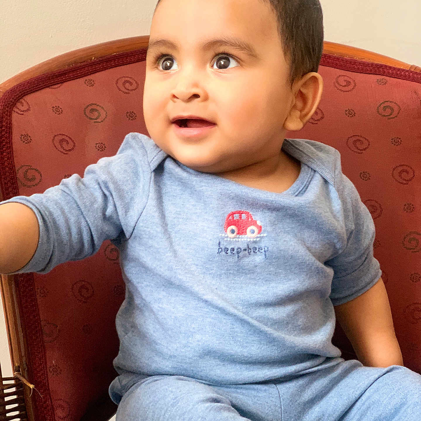 Hyzin is registered to the contest to win money with this photo: baby, blue_pajamas, chair, child, cozy, curious, cute, expression, face, happy, indoor, patterned_chair, person, portrait, seated, short_hair, small_car_emblem, smiling, toddler, young_child