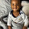 baby, child, smiling, happy, indoors, blanket, bed, clothing, person, portrait, cute, infant, face, young, cozy, sleepwear, expression, warm, comfort, toddler