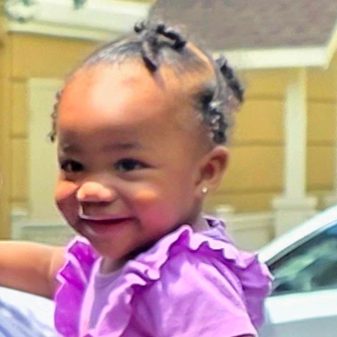Aeris joined the competition — help win amazing prizes! toddler, child, smile, purple_shirt, hair_twists, earrings, outdoor, daylight, car, house, person, cute, happy, portrait, ruffles, skin, face, holding, background, sunlight