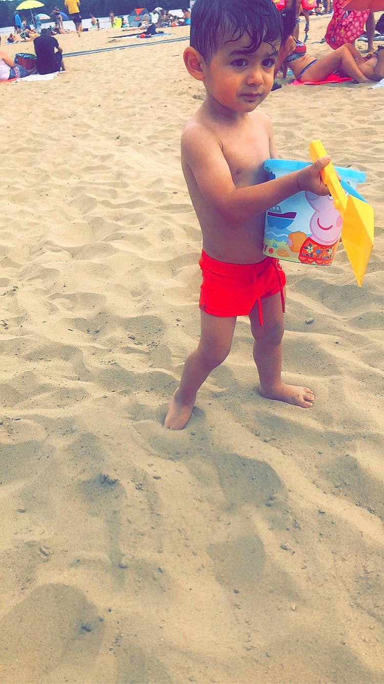 Amir participe au concours pour gagner de l'argent avec cette photo : baby, barefoot, beach, blue, body_of_water, foot, fun, happy, hat, leisure, light, people_in_nature, people_on_beach, person, personal_protective_equipment, sand, shorts, singing_sand, swimwear, toddler