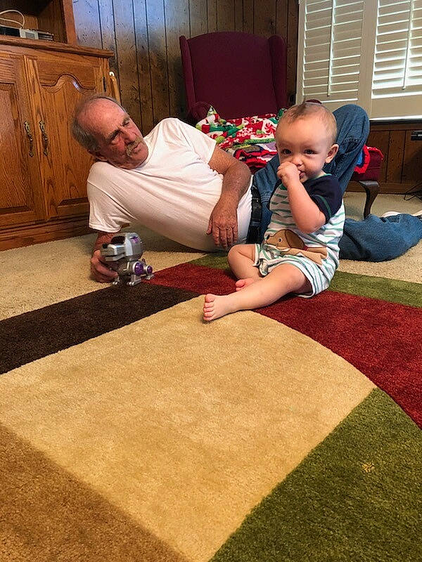 Bryer is registered to the contest to win money with this photo: carpet, child, day, floor, flooring, fun, hardwood, infant, leg, pattern, person, play, sitting, textile, toddler, wood, wood_flooring