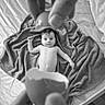 baby, bed, black_and_white, blanket, curious, eggshell, expression, fingers, hand, indoor, infant, lying_down, mattress, monochrome, newborn, person, portrait, skin, soft_texture, wide_eyes