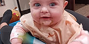 Mckenna is registered to the contest to win money with this photo: baby, bib, blue_eyes, carpet, chair, child, clothing, cute, expression, face, floor, furniture, hands, happy, indoor, infant, messy, person, play, toy