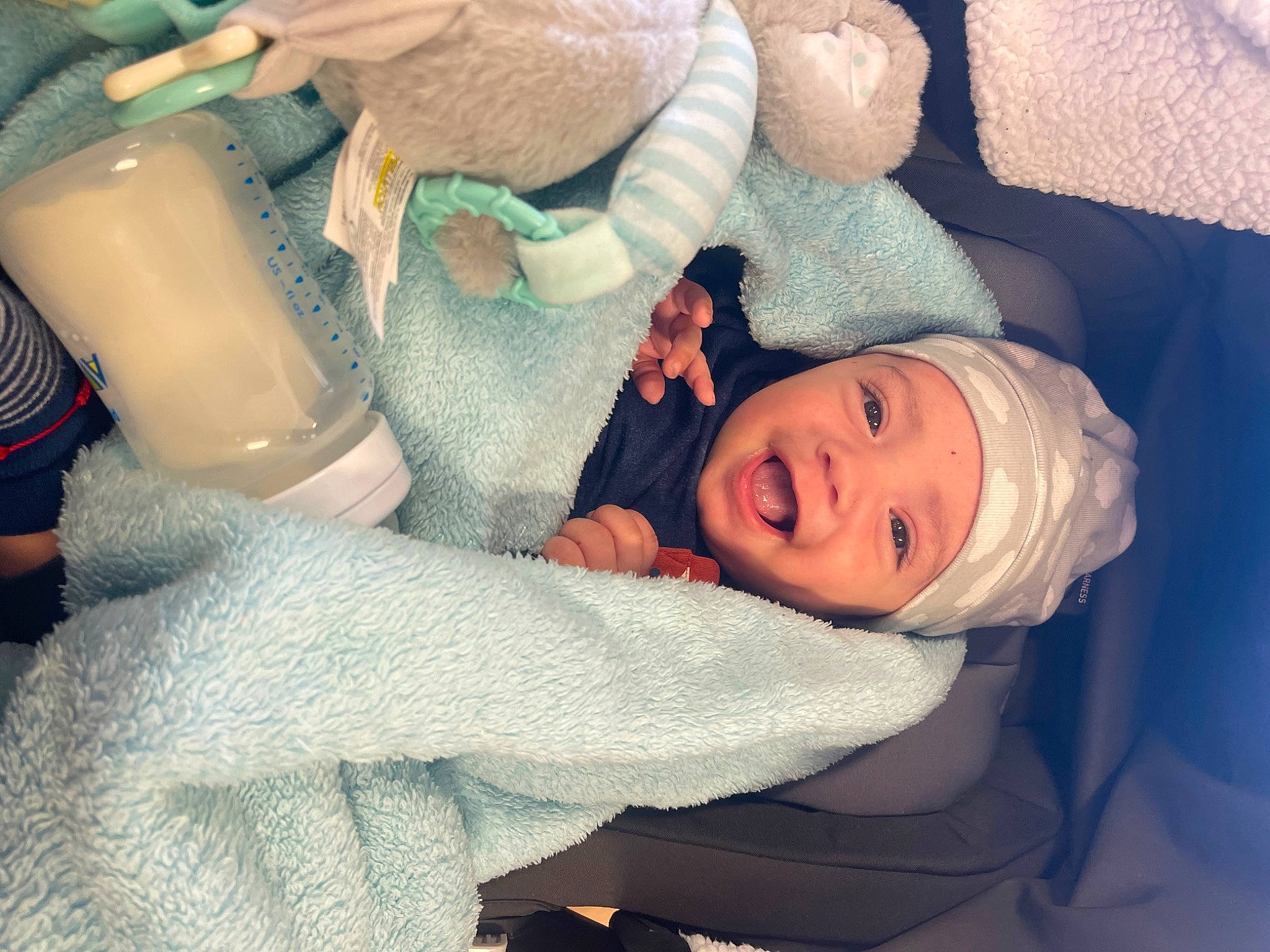 Adriel is registered to the contest to win money with this photo: baby, baby_sleeping, child, comfort, drinking, finger, hand, hat, headwear, human_body, human_leg, linens, mouth, nap, person, plastic_bottle, room, skin, sleep, smile