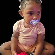 Ahlani joined the competition — help win amazing prizes! toddler, child, pacifier, hair_clips, flower, pink_clothing, toy, sitting, cross_legged, young_child, cute, indoor, skin, short_sleeve, curious, baby, person, playful, infant, holding