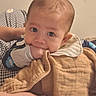 baby, infant, hand, blanket, clothing, face, eyes, indoor, curtain, bed, soft_lighting, chewing, resting, person, cute, young_child, toddler, sleepwear, comfort, holding