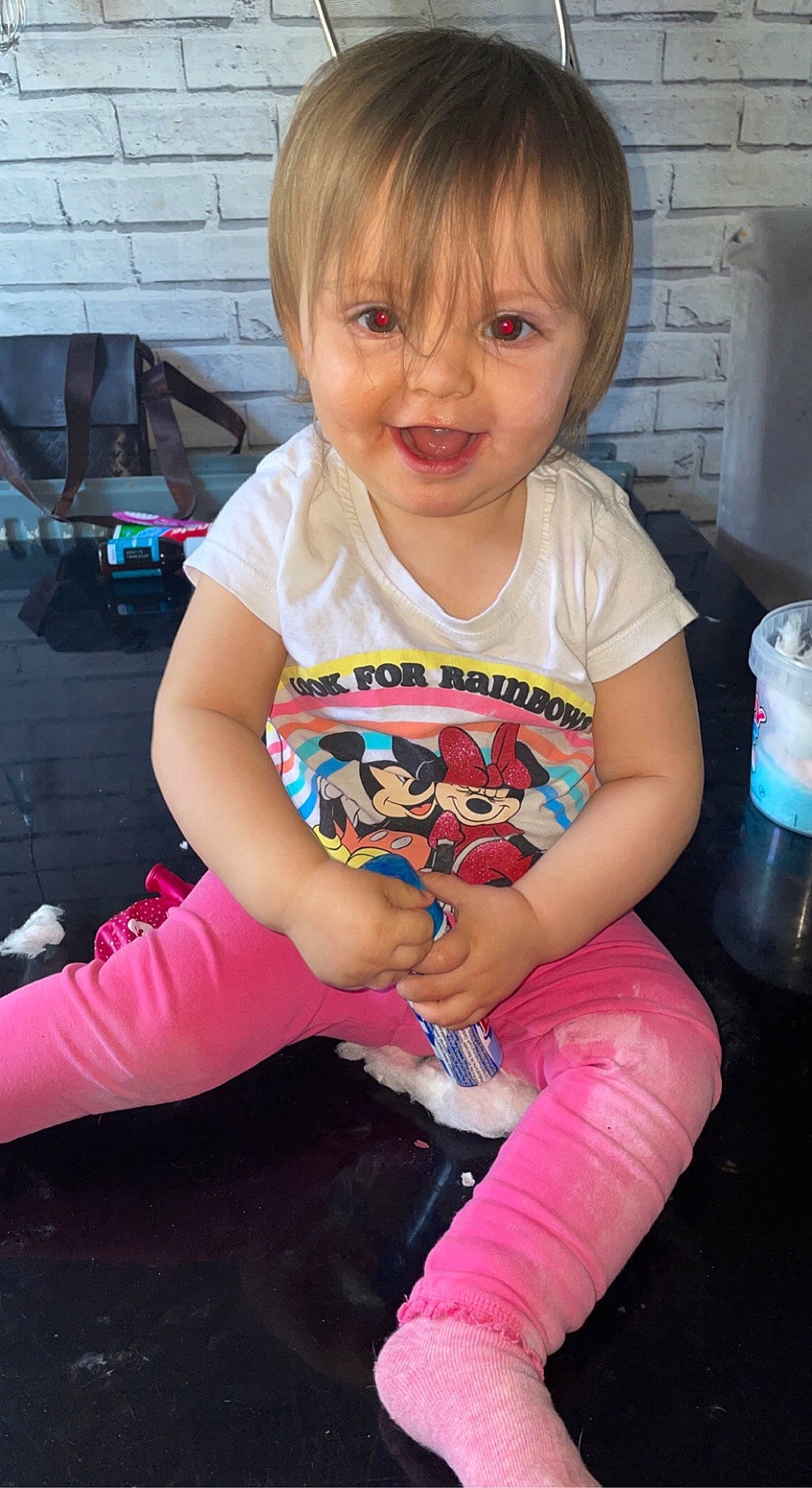 Skyla is registered to the contest to win money with this photo: baby_toddler_clothing, blond, cheek, child, clothing, eye, fun, hairstyle, happy, human_leg, knee, person, pink, plastic_bottle, sitting, sleeve, smile, t_shirt, thigh, toddler