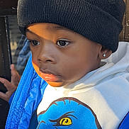 Shawn is registered to the contest to win money with this photo: beanie, blue_jacket, casual, child, clothing, cute, dinosaur_graphic, earring, expression, face, fashion, outdoor, person, portrait, sunlight, thoughtful, warm_light, white_hoodie, window, young