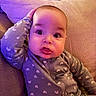 Milo is registered to the contest to win money with this photo: baby, child, pajamas, couch, cushion, face, expression, hand, head, indoors, person, portrait, purple_lighting, sitting, soft_lighting, cozy, cute, infant, clothing, home