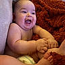 baby, infant, smiling, happy, chubby_cheeks, bare_skin, blanket, cushion, purple, rust_color, diaper, feet, hands, cute, indoors, portrait, child, playful, soft_texture, cozy