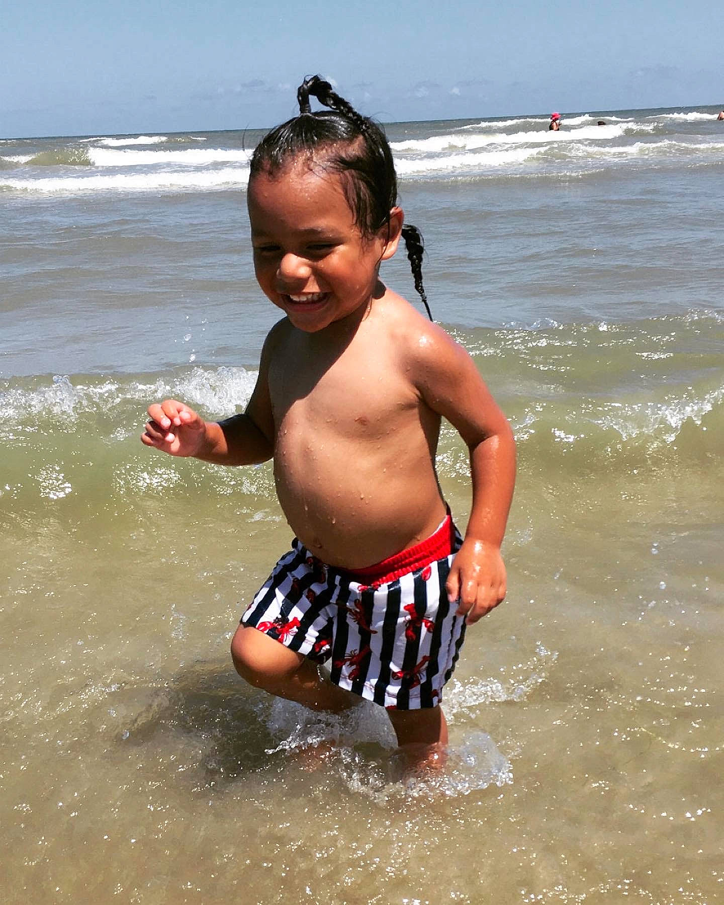 Kenneth is registered to the contest to win money with this photo: bathing, beach, chest, face, fun, happy, head, human_body, joy, leisure, liquid, people_in_nature, people_on_beach, person, sky, smile, summer, swimwear, toddler, trunk