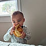 toddler, child, bread, eating, indoor, window, curious, quilt, bedroom, light, casual, infant, snack, person, young_child, cute, cozy, hand, face, apparel
