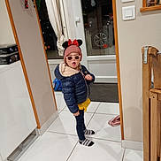 Mylana a rejoint le concours — aidez-le/la à gagner de superbes lots ! accessories, child, cozy, curtains, door, hat, home_interior, indoor, minnie_mouse, person, puffy_jacket, standing, striped_socks, sunglasses, surprised_expression, tiled_floor, toy, winter_clothing, wooden_chair, yellow_skirt