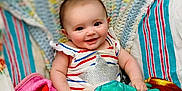 Nevaeh joined the competition — help win amazing prizes! baby, blanket, child, colorful, comfort, cozy, cute, fabric, face, hand, happy, head, indoor, infant, playful, plush, portrait, smiling, soft_toy, striped_clothing