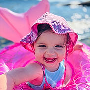 Lily-Rose a rejoint le concours — aidez-le/la à gagner de superbes lots ! baby, blue_sky, child, cute, fun, happy, headwear, holiday, inflatable_float, outdoor, pink_hat, play, smiling, summer, sunny, swimming, toddler, toy, vacation, water
